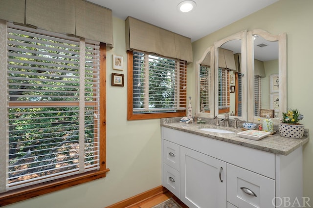 bathroom featuring visible vents, vanity, and baseboards