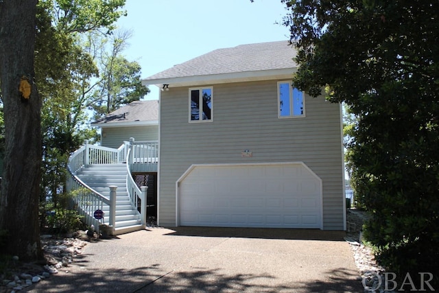 back of property featuring stairs and a garage