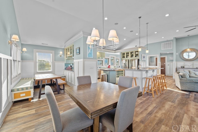 dining area featuring a wainscoted wall, visible vents, and light wood-style flooring