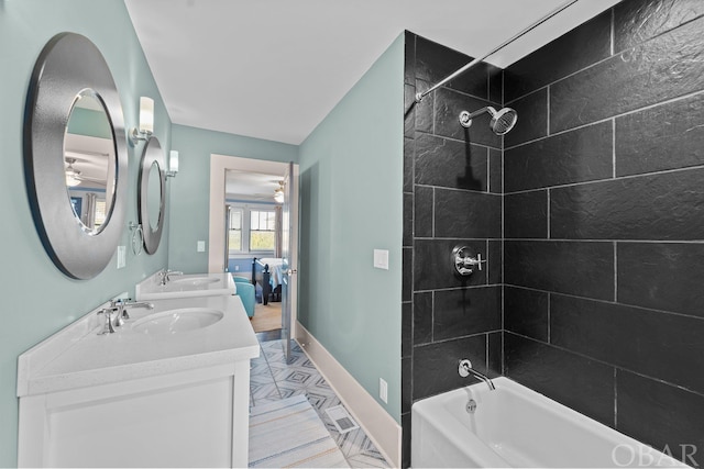 bathroom with tub / shower combination, a sink, baseboards, and double vanity