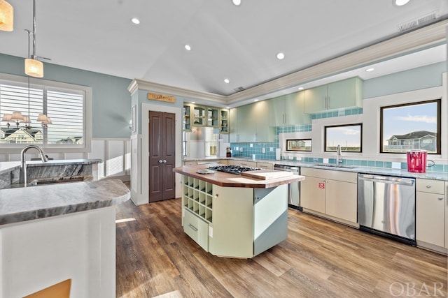 kitchen with a center island, pendant lighting, open shelves, stainless steel appliances, and glass insert cabinets