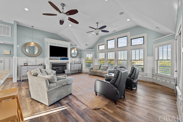 living area featuring a healthy amount of sunlight, a fireplace, visible vents, and wood finished floors