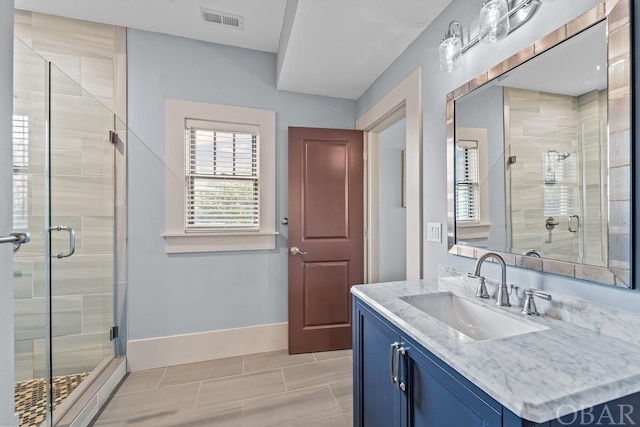 full bath featuring visible vents, a shower stall, baseboards, and vanity