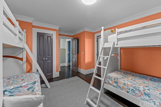 bedroom featuring baseboards, dark wood-style flooring, and crown molding