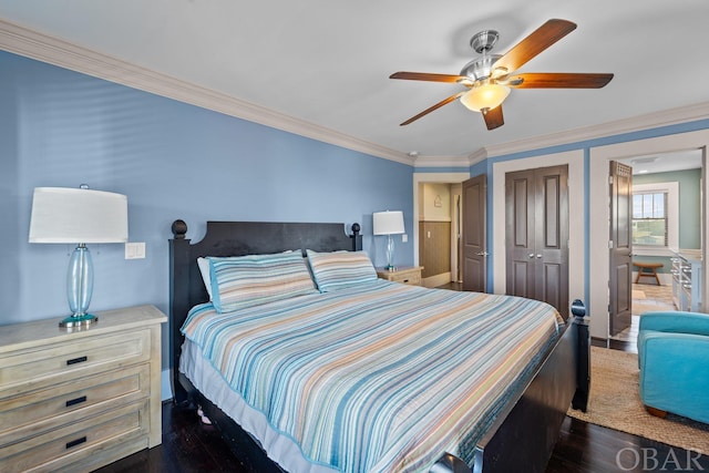 bedroom featuring a closet, dark wood-style flooring, ornamental molding, and a ceiling fan