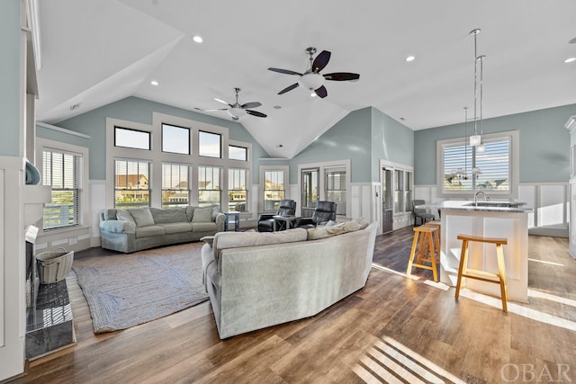 living room featuring recessed lighting, a wainscoted wall, vaulted ceiling, and wood finished floors