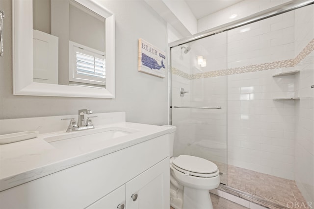 full bathroom with a stall shower, vanity, and toilet