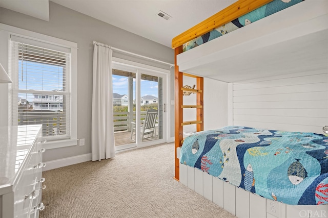 carpeted bedroom with access to outside, visible vents, and baseboards