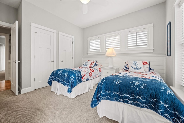 carpeted bedroom with a ceiling fan and baseboards