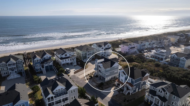 drone / aerial view featuring a water view, a residential view, and a view of the beach