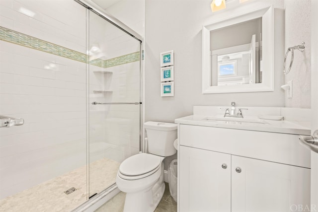 bathroom featuring a stall shower, tile patterned flooring, vanity, and toilet