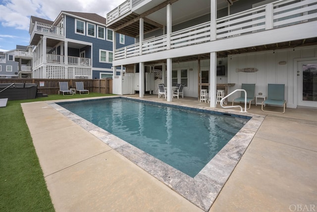 view of swimming pool featuring exterior bar, fence, a fenced in pool, and a patio