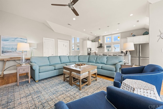 living room featuring light wood-style flooring, vaulted ceiling, and recessed lighting