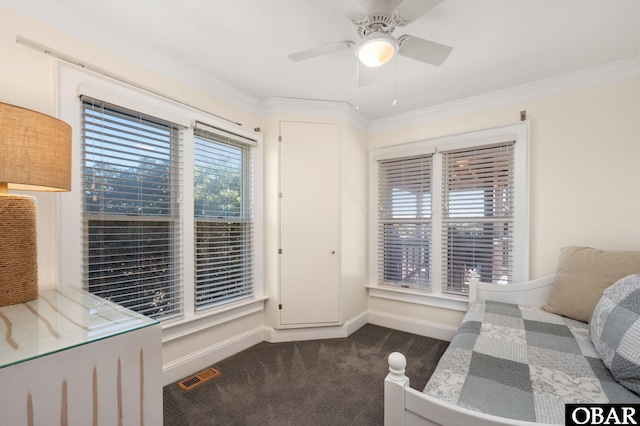 carpeted bedroom with visible vents, baseboards, a ceiling fan, and crown molding