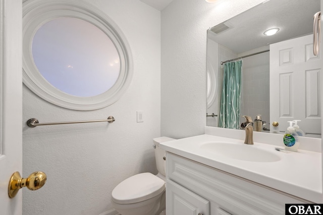 full bathroom with toilet, vanity, a shower with curtain, and a textured wall