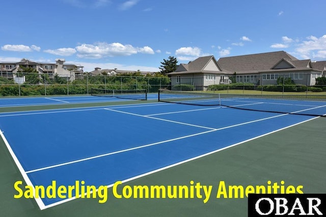 view of tennis court with community basketball court and fence