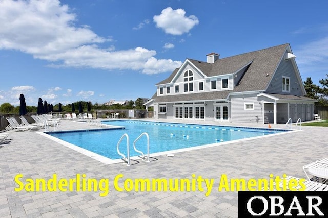 community pool with a patio and fence