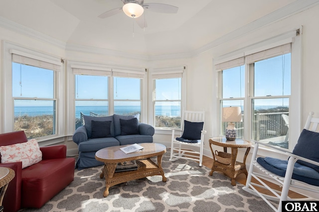 living room with a raised ceiling, wood finished floors, a ceiling fan, and ornamental molding