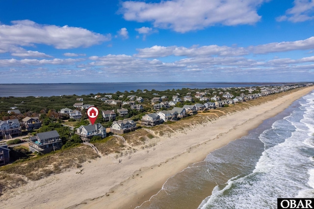 birds eye view of property featuring a beach view and a water view