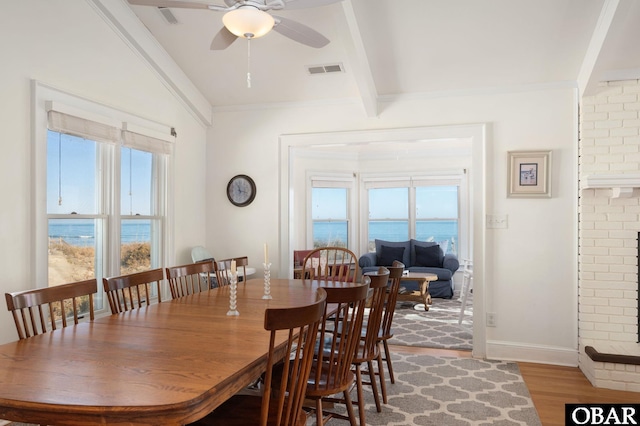 dining space featuring visible vents, baseboards, ceiling fan, beamed ceiling, and light wood-type flooring