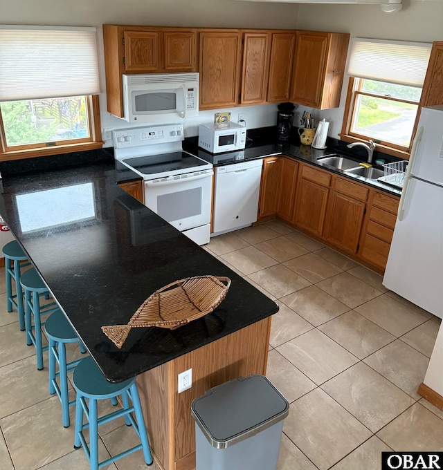 58221 Liberator Way Lot 1-3, Hatteras, NC 27943 - kitchen featuring white appliances, dark countertops, brown cabinets, a kitchen breakfast bar, and light tile patterned floors