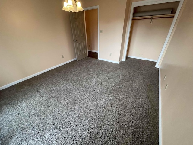 unfurnished bedroom with a closet, baseboards, and dark colored carpet
