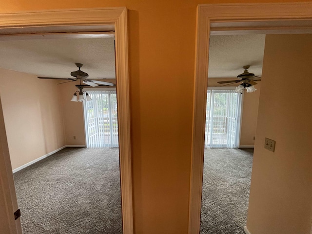 hallway with baseboards, a textured ceiling, and carpet