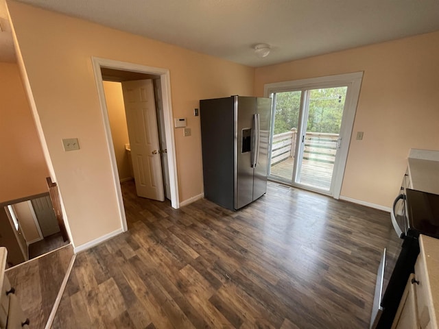 interior space with access to exterior, stainless steel fridge with ice dispenser, dark wood-type flooring, and baseboards