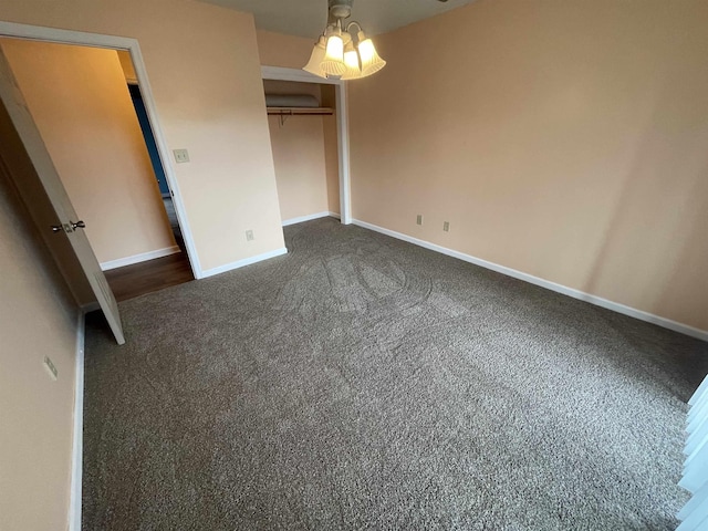 unfurnished bedroom featuring a closet, baseboards, and dark colored carpet