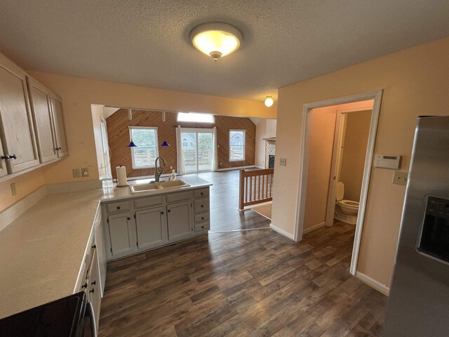 kitchen featuring dark wood-type flooring, electric range, light countertops, and a sink