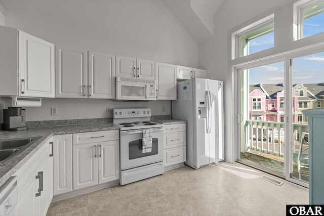 1107 Cambridge Rd Unit 305-F, Kill Devil Hills, NC 27948 - kitchen featuring white appliances, high vaulted ceiling, white cabinets, and a sink