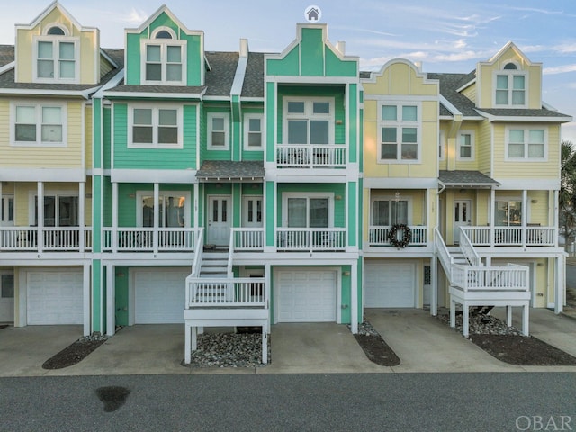 view of front of property featuring a garage, roof with shingles, and driveway