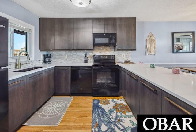 24250 Resort Rodanthe Dr Unit 12B, Rodanthe, NC 27968 - kitchen featuring black appliances, dark brown cabinetry, light countertops, and a textured ceiling