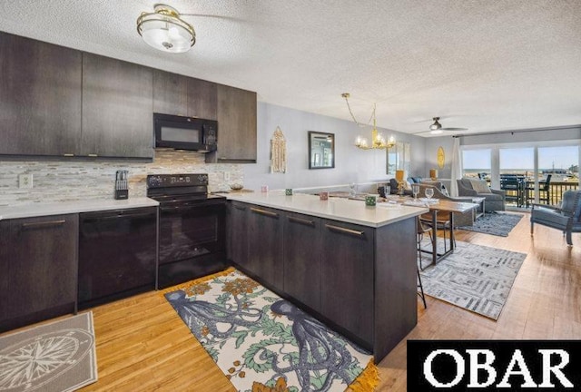 24250 Resort Rodanthe Dr Unit 12B, Rodanthe, NC 27968 - kitchen with black appliances, a textured ceiling, light countertops, a peninsula, and decorative backsplash