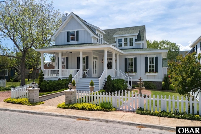 504 Lord Essex Ave, Manteo, NC 27954 - view of front of home featuring stairs, a shingled roof, a fenced front yard, board and batten siding, and covered porch