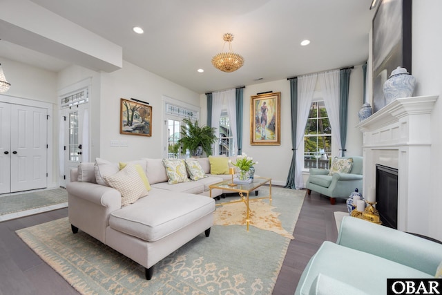 504 Lord Essex Ave, Manteo, NC 27954 - living area with baseboards, dark wood-style floors, a chandelier, a glass covered fireplace, and recessed lighting