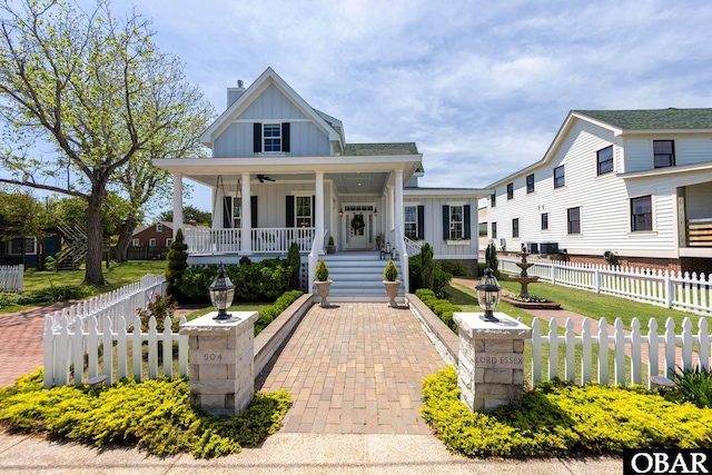 504 Lord Essex Ave, Manteo, NC 27954 - view of front of home with a ceiling fan, covered porch, board and batten siding, and a fenced front yard