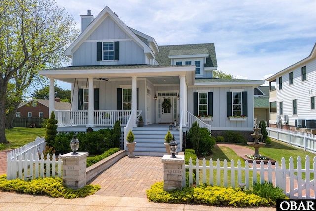 504 Lord Essex Ave, Manteo, NC 27954 - modern inspired farmhouse featuring a porch, central AC unit, board and batten siding, and a shingled roof
