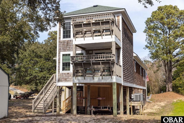 rear view of property with stairs, a balcony, and cooling unit