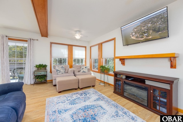 living room with beam ceiling, baseboards, and wood finished floors