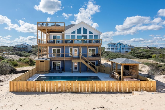 rear view of property featuring a patio area, a fenced backyard, a fireplace, and a fenced in pool