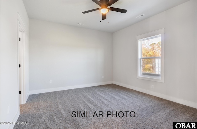 carpeted empty room with visible vents, ceiling fan, and baseboards