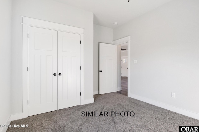unfurnished bedroom featuring carpet, a closet, and baseboards