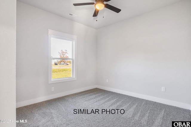 carpeted spare room with a ceiling fan, visible vents, and baseboards