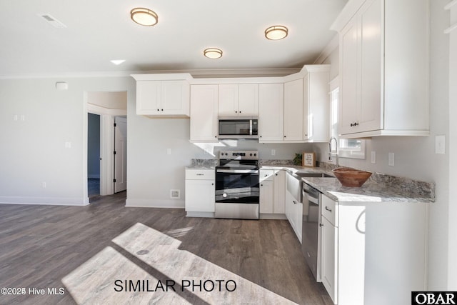 kitchen featuring light stone counters, stainless steel appliances, visible vents, dark wood-type flooring, and white cabinetry