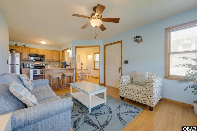 2009 Wrightsville Blvd Unit 4-B, Kill Devil Hills, NC 27948 - living room with healthy amount of natural light, a ceiling fan, light wood finished floors, and baseboards