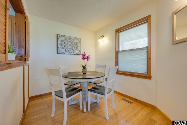 2009 Wrightsville Blvd Unit 4-B, Kill Devil Hills, NC 27948 - dining room featuring light wood finished floors, baseboards, and a textured ceiling
