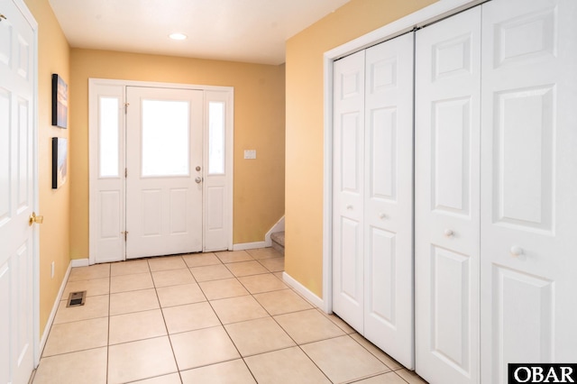 entryway with light tile patterned floors, stairway, visible vents, and baseboards