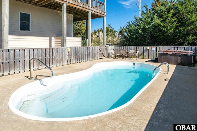 view of pool with a hot tub, a fenced in pool, a fenced backyard, and a patio