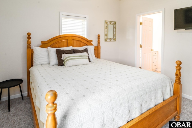 carpeted bedroom featuring baseboards and connected bathroom